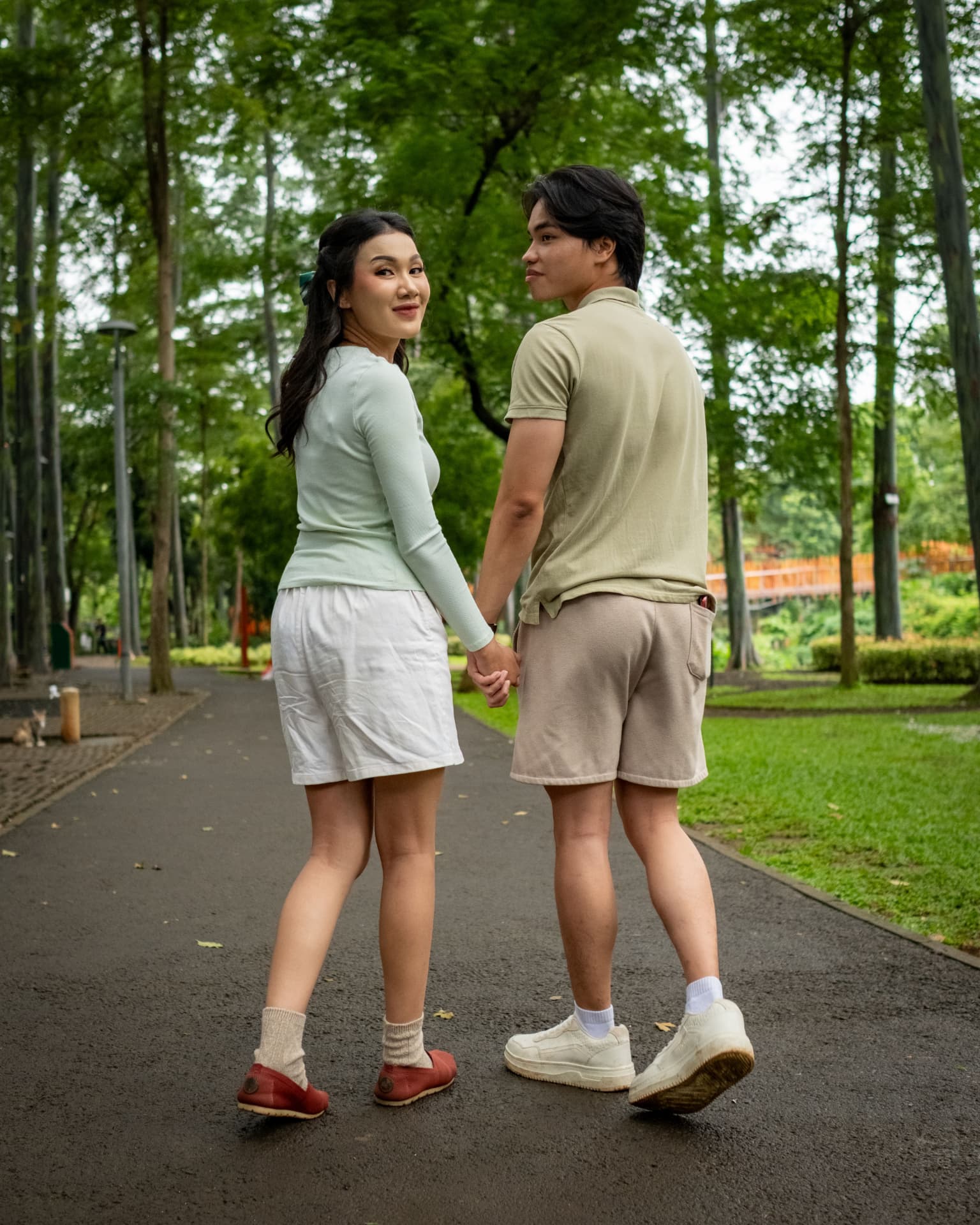 Pasangan bergandengan di taman kota